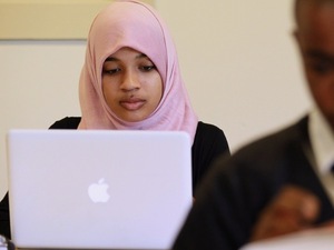 A young Muslim woman uses her computer.