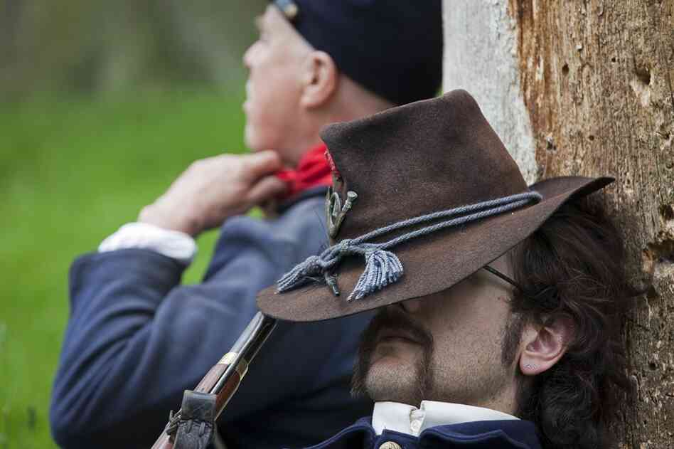 Pvt. Charles Elwood rests against a tree before continuing to march into a battle.