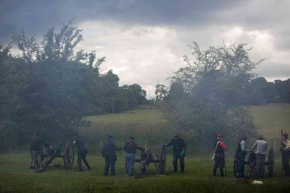 Cannon smoke fills the air during the early stages of battle. The re-enactors use black powder for firing cannons, just as they do with guns.