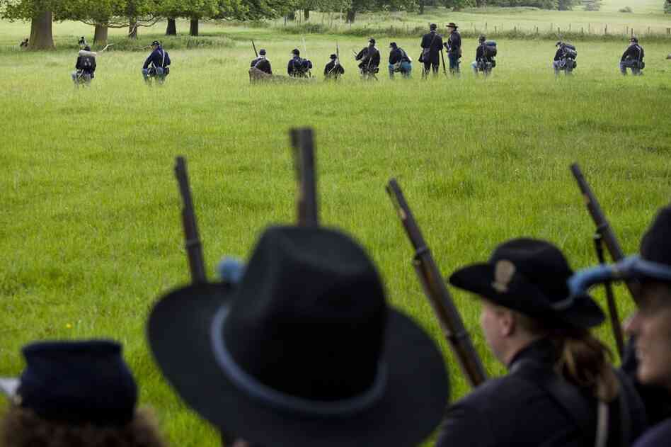 Union re-enactors pause while making their way to a field to fight their "enemy."