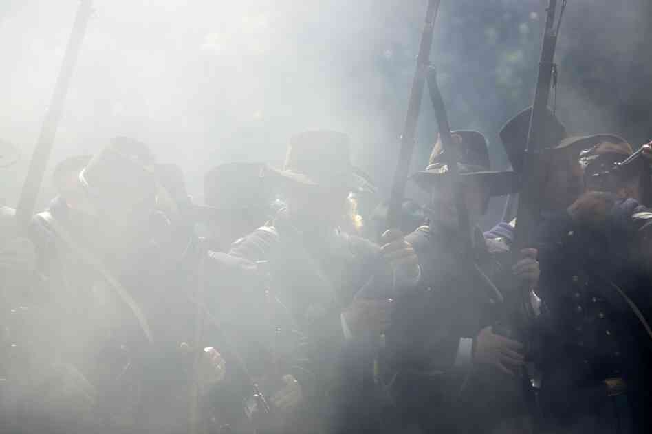 Union re-enactors are shrouded in smoke during a battle.