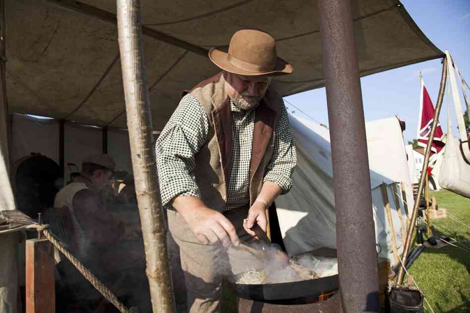 A Confederate re-enactor prepares a meal at a camp set up in the town of Hingham, England. Re-enactors came to Hingham for a festival honoring Abraham Lincoln, whose ancestor Samuel Lincoln immigrated to America from Hingham.