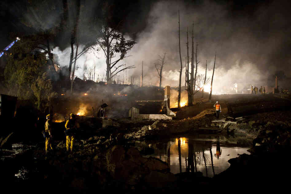 A crater filled with water marks the site of the explosion that caused the fire. After the initial blast, flames reached as high as 100 feet as the fire fueled itself on burning homes, leaving some in total ruins. 