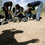 A U.S. Border Patrol agent casts a shadow below a group of migrants detained near Arivaca, Ariz. A U.S. Border Patrol agent casts a shadow below a group of migrants detained near Arivaca, Ariz.
