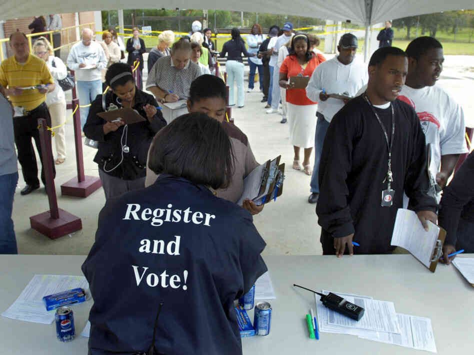 Board of Elections Customer Service Supervisor Sabrina German hands out absentee ballots in 2008.