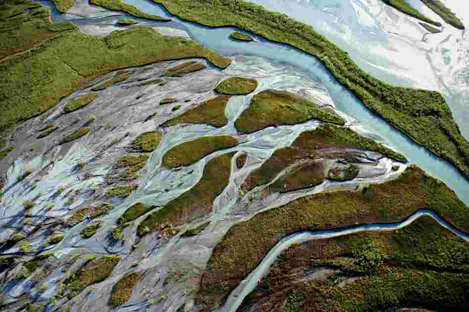 Sunlight is reflected along Alaska's Neacola River.