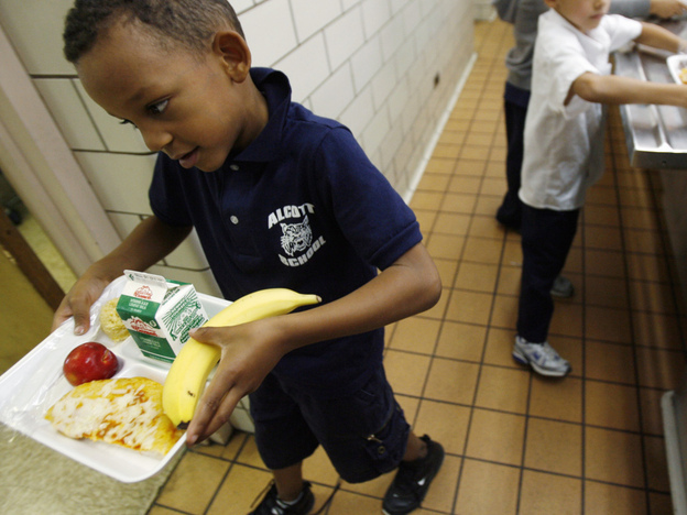 A student at the Louisa May Alcott Elementary School in Chicago carries his lunch tray. (AP)