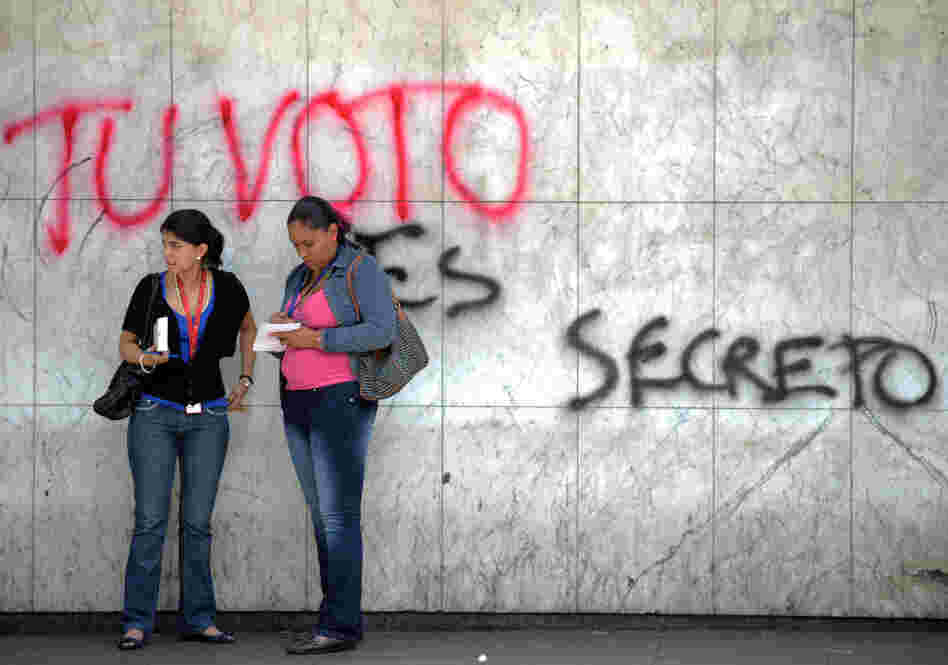 Two women talk in front of a graffiti al Two women talk in front of a graffiti al