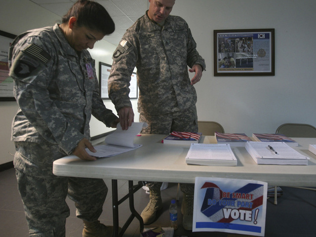 A U.S. member of Combined Joint Task Force 101, left, checks a voting ballot