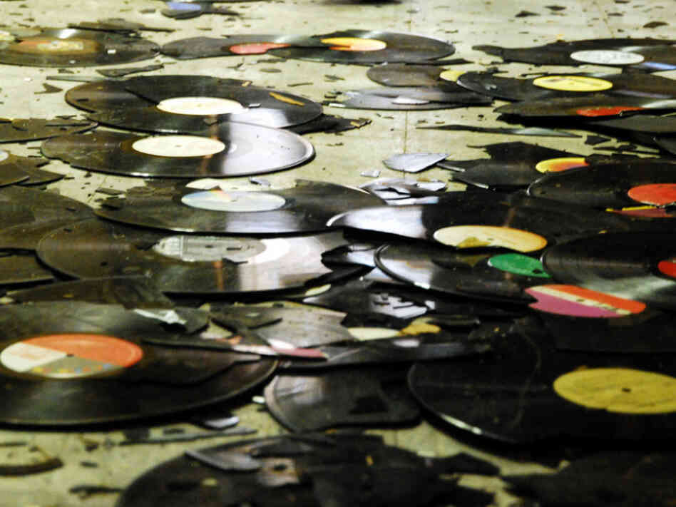 Broken records on the floor of a warehouse