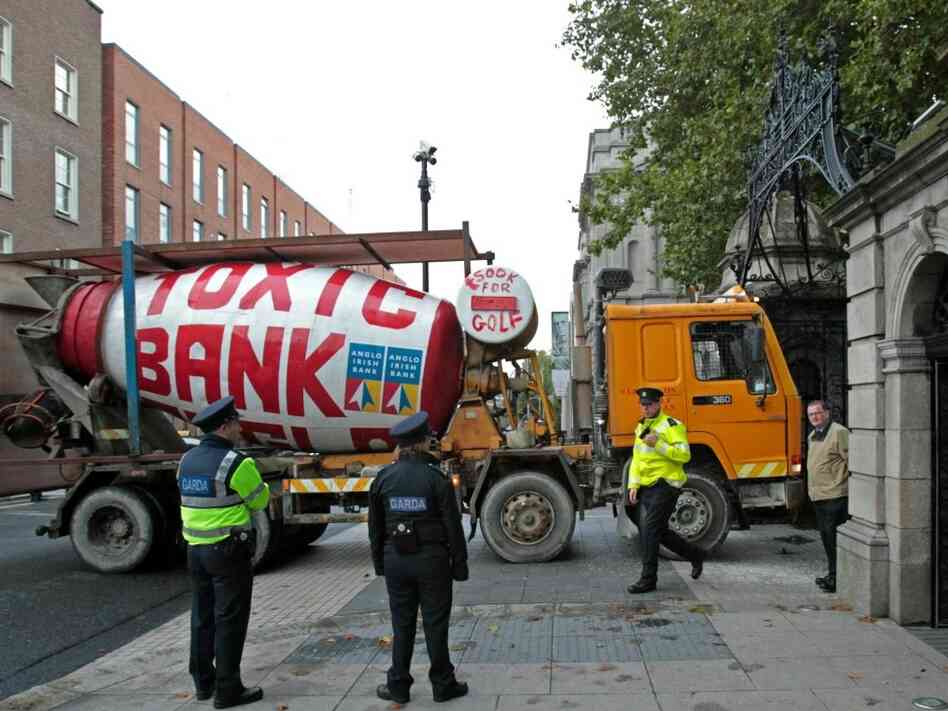 Irish police officers look at a cement mixer driven into the gate of Ireland's Parliament building. Irish police officers look at a cement mixer driven into the gate of Ireland's Parliament building.