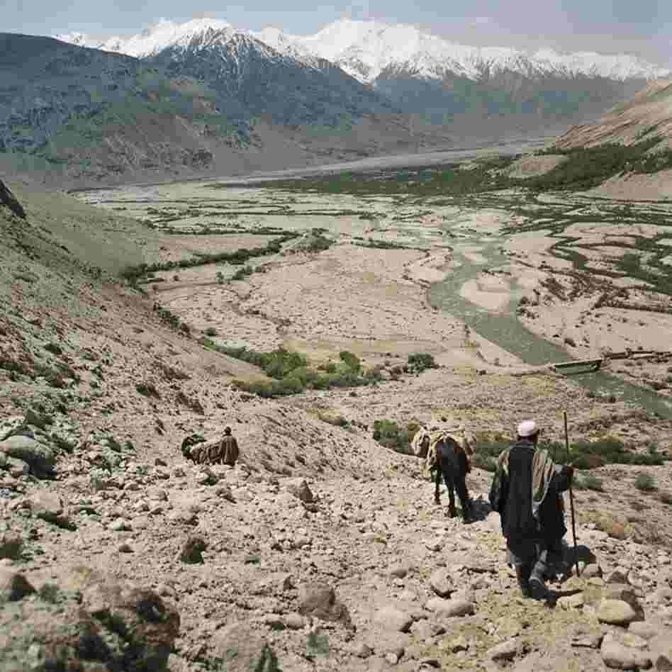 Wakhi men hike to the base of Big Pamir Mountain as they return to their village in the Wakhan Corridor, in the province of Badakshan in Afghanistan's northeast corner.