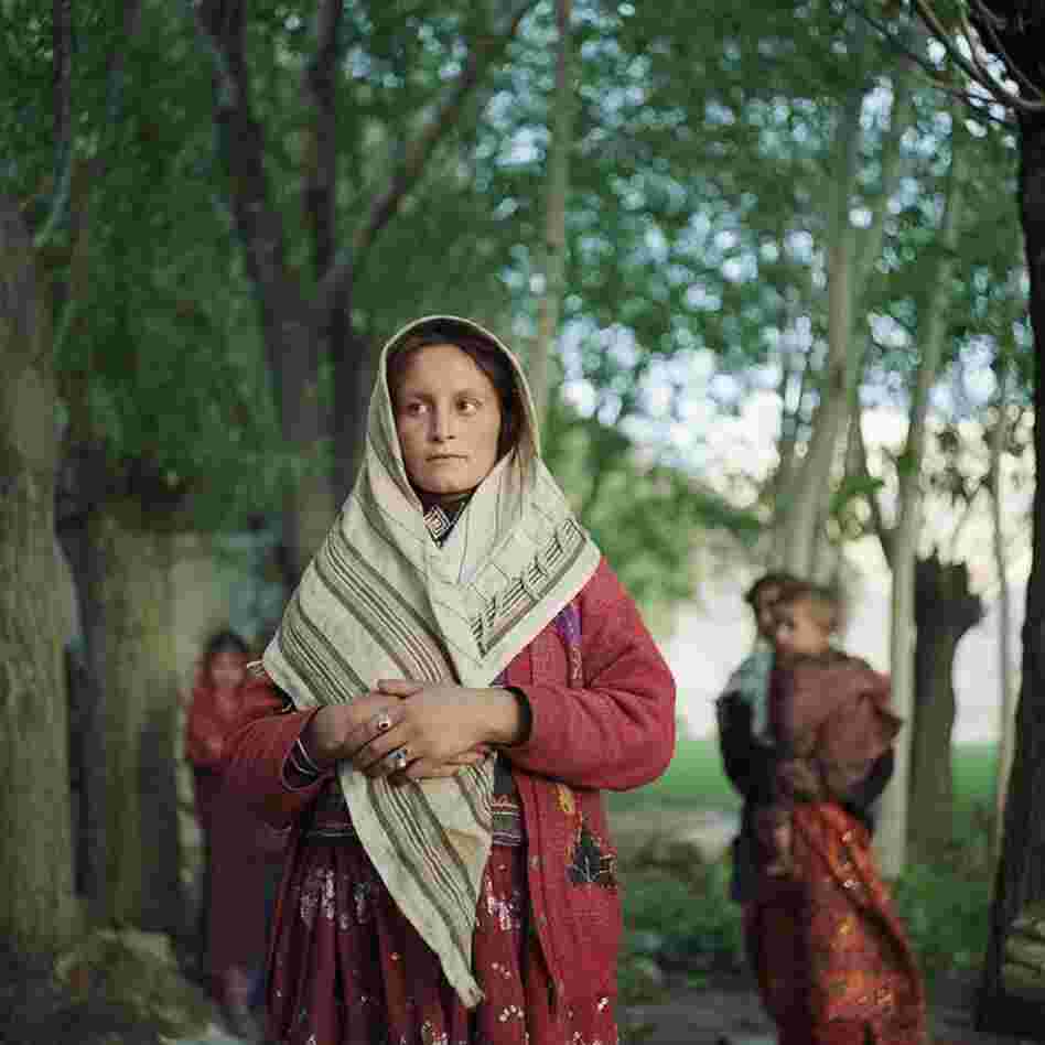 A Wakhi woman stands near her family in the village of Ghaz Khan.