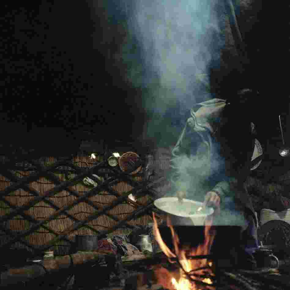 A Wahki shepherd boils goats milk inside of the yurt that he shares with three other men.