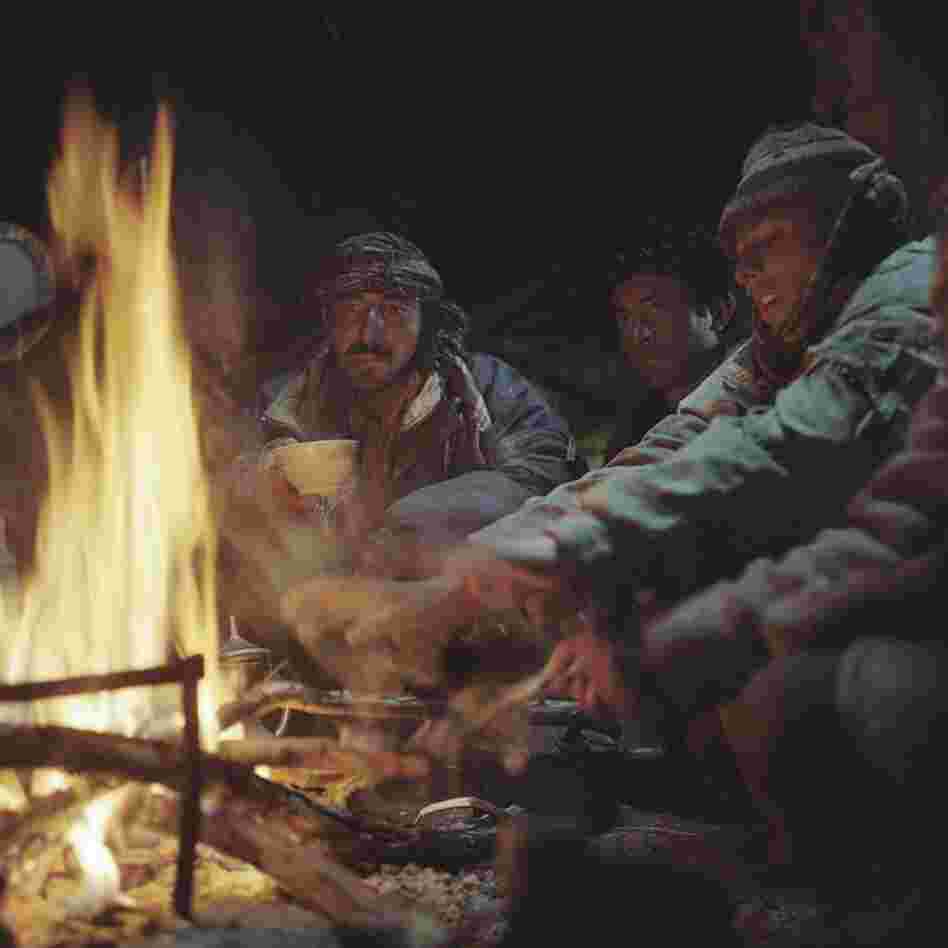 Wakhi shepherds and horsemen warm themselves by a fire in their yurt in the Wakhan Corridor.