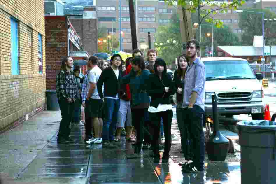 Fans wait outside in the rain to get into the 9:30 Club in Washington, D.C.