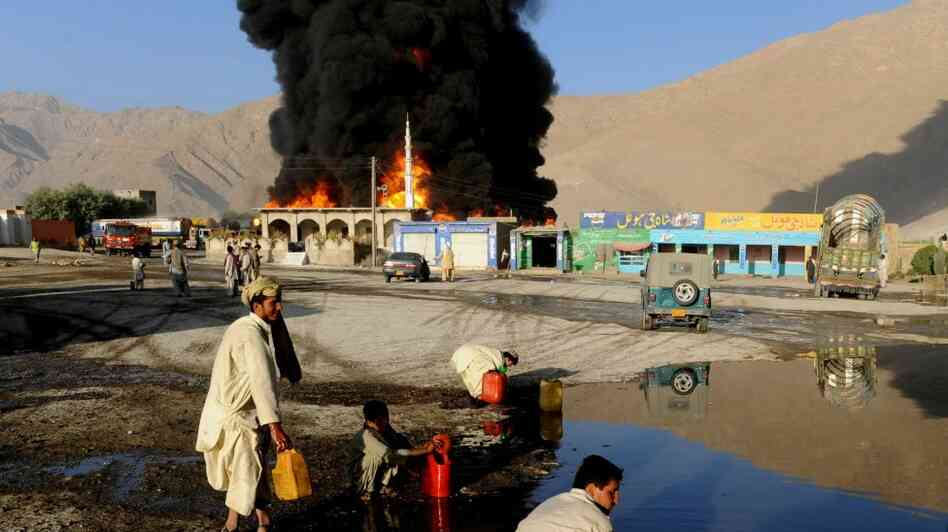 Local residents collect oil from the burning oil depot after gunmen attacked NATO tankers in Quetta Local residents collect oil from the burning oil depot after gunmen attacked NATO tankers in Quetta