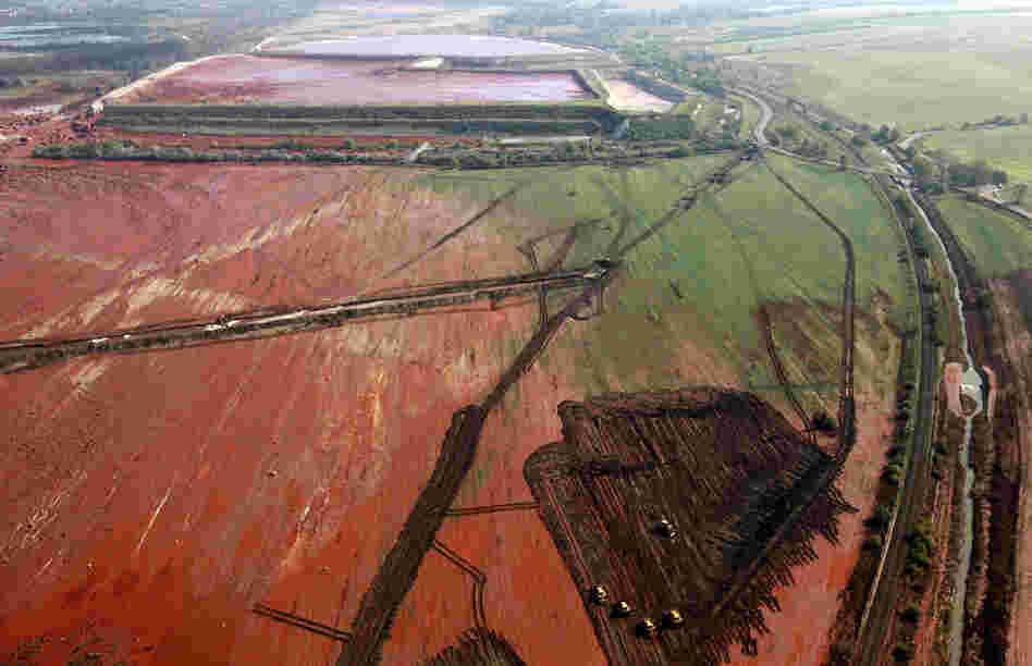 An aerial photo taken on Oct. 8, 2010, shows the ruptured wall of a red sludge reservoir of the Ajkai Timfoldgyar plant in Kolontar, Hungary. A wave of toxic red mud swept through the small village, killing five and injuring scores more. 