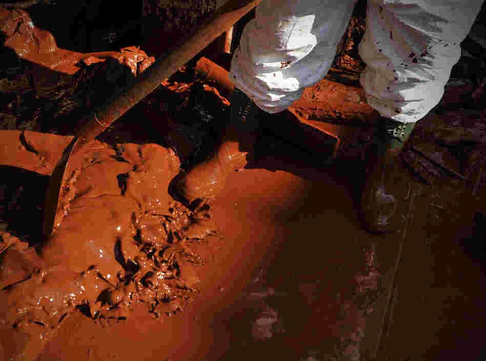 A Hungarian soldier, wearing protective gear, shovels toxic mud out of a house in Devecser, Oct. 7. The toxic red sludge that inundated three Hungarian villages reached Europe's Danube River on Thursday, but no immediate damage was evident, Hungary's rescue operations agency said. 
