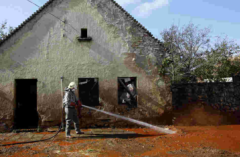 A Hungarian firefighter cleans a street flooded by toxic mud in Devecser, Hungary, Oct. 7. The flood of toxic mud killed several people and injured more than 100. Some people are still reported missing. 