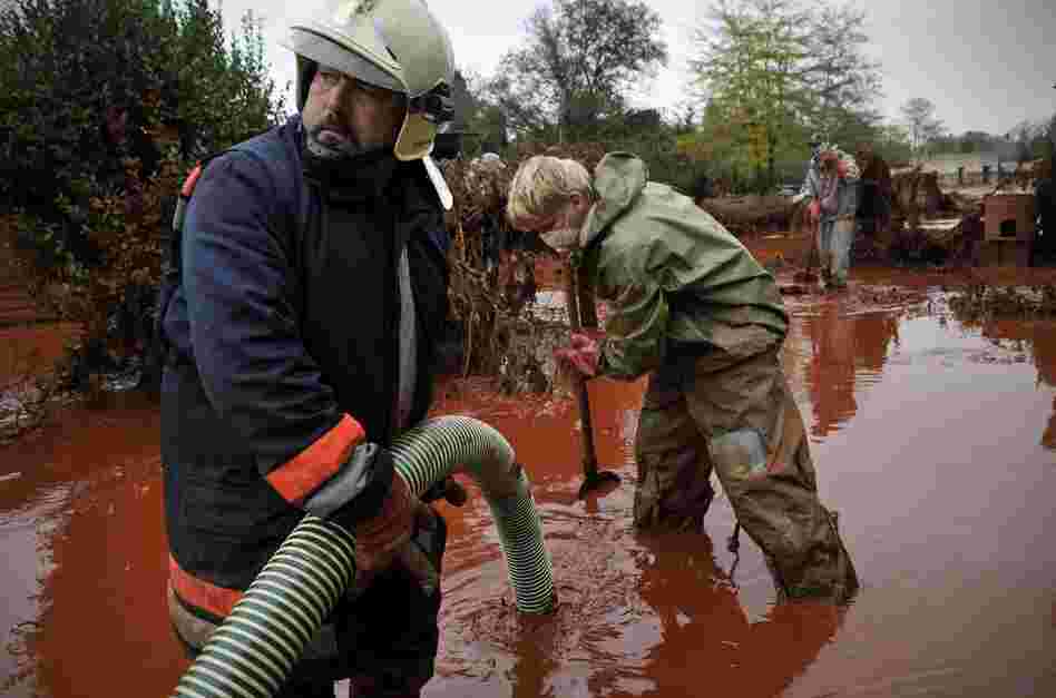 Hungarian firefighters pump sludge from a yard flooded by the toxic mud in Devecser, Oct. 6. 