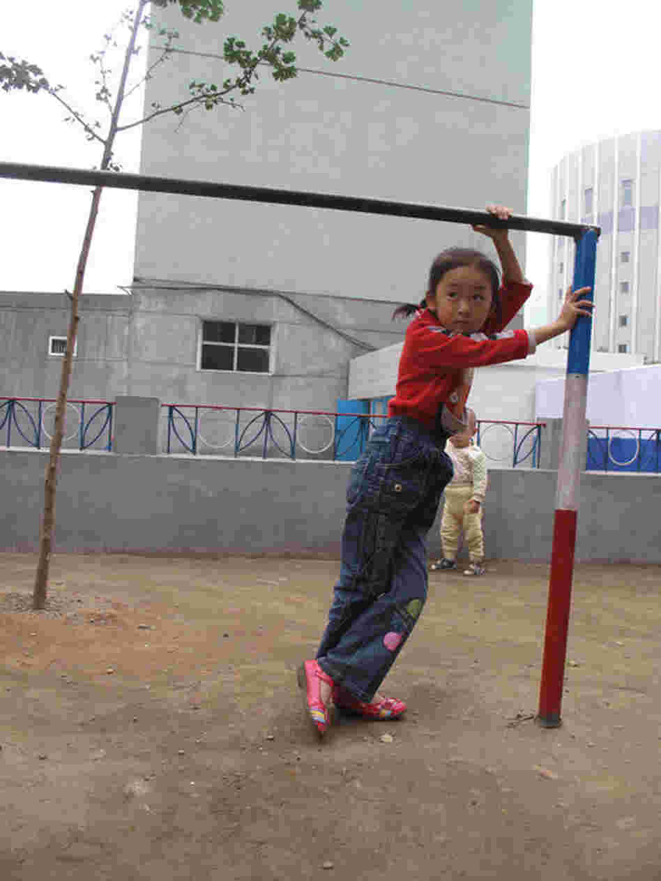A young girl plays in a dilapidated playground in Pyongyang.
