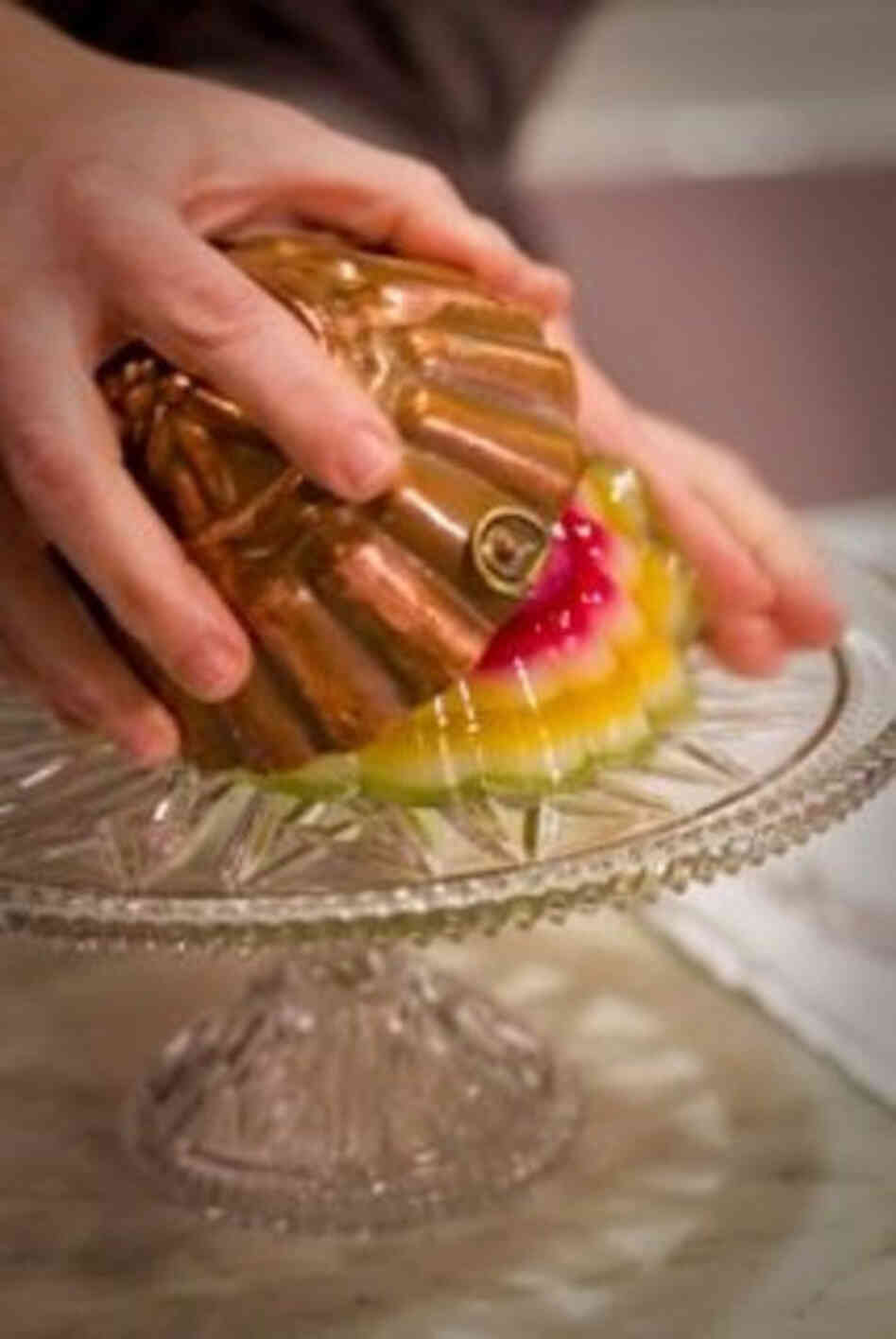 American Victorian jelly molds were commonly made from steel and rarely strayed from simple oval and circle designs.  Here, a cook unmolds the Layered Lemon Jelly.