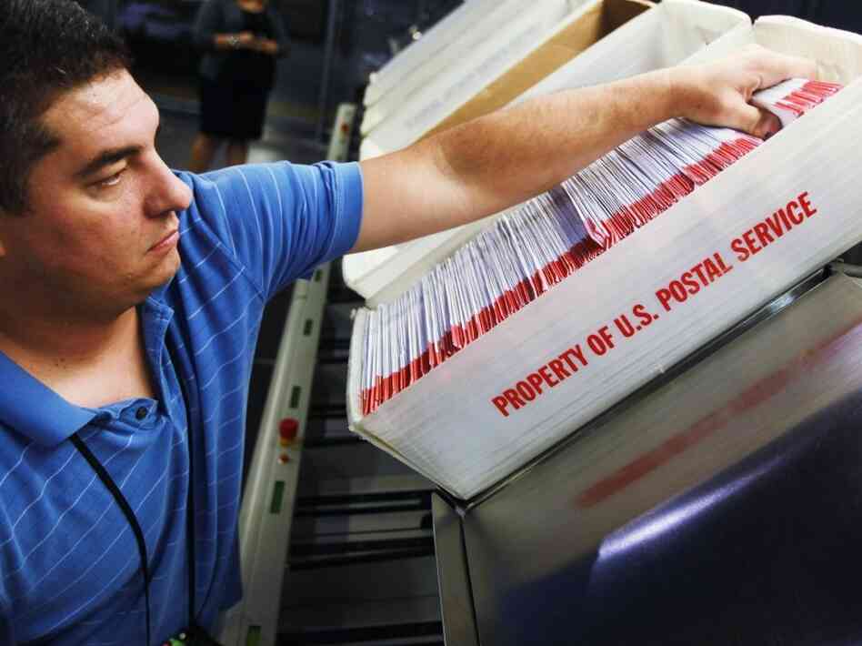 Julio Galligaris sorts through mail-in ballots that have been received in Doral, Fla. Julio Galligaris sorts through mail-in ballots that have been received in Doral, Fla.