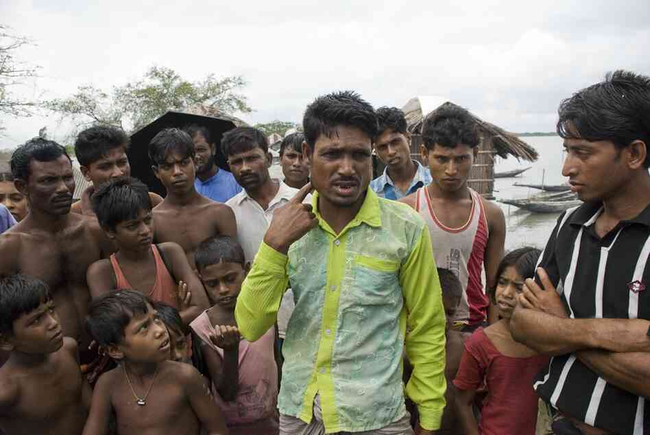 Ahmad Sheik explains to his community how the tiger attacked Shabut Malik. He had been with Malik, and hit the tiger with his oar in an attempt to help. In this fishing village of Gabura, six people were killed by tigers in the most recent month.