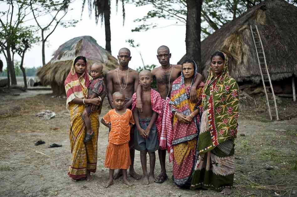 The family of Niren Sarkar, a 55-year-old fisherman, poses for a portrait. The fisherman was killed in the jungle five days earlier. Sarkar's sons will continue fishing in the forest to support the family, as other jobs are scarce.