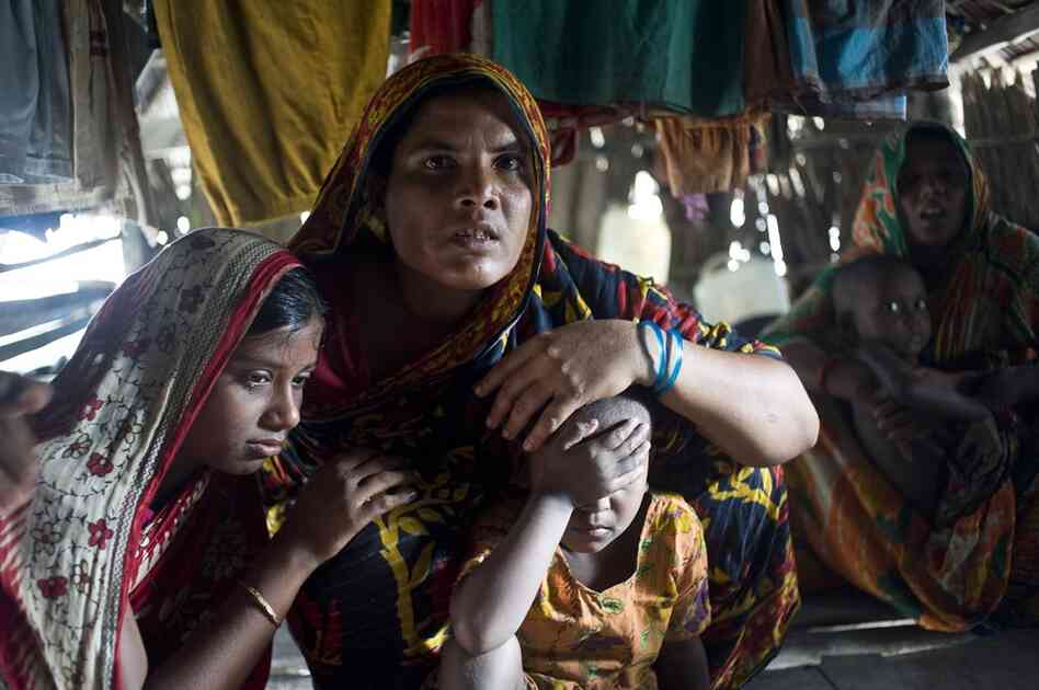 Fisherman Shabut Malik, not pictured, was attacked by a tiger one hour earlier while fishing in the forest. Nunnar Kathun, widow of a tiger victim, sympathizes with Malik's family.