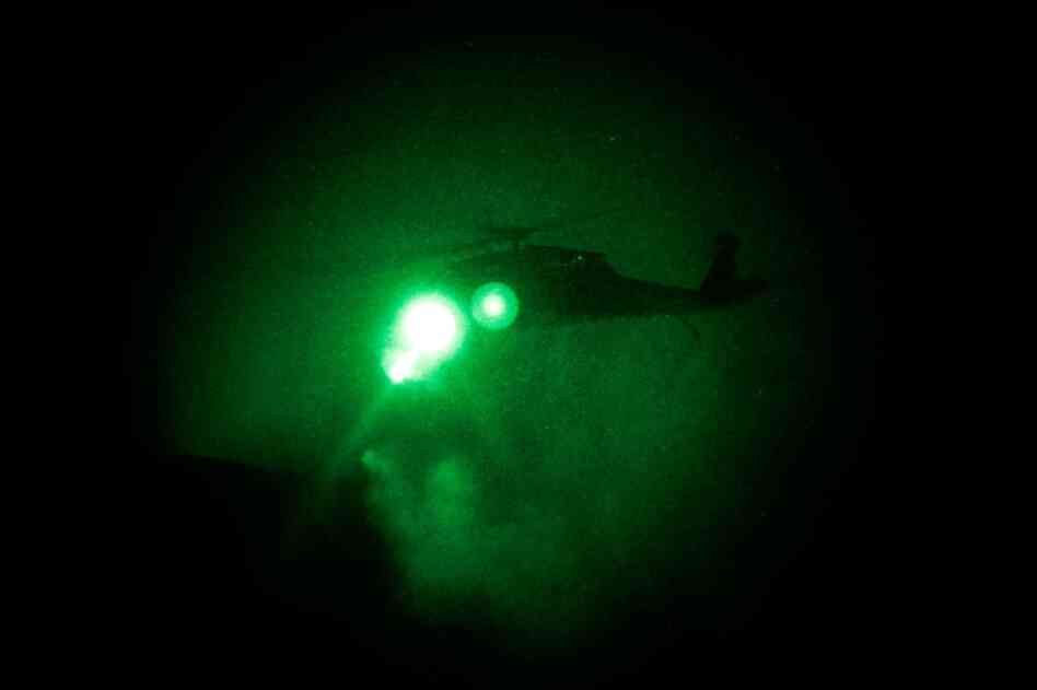 An Army Black Hawk helicopter is seen through a night vision lens as Alpha Company attempts to guide it to a landing near the disabled helicopter. The landing zone is too small, and the men must jump from their hovering chopper. By the time they reach the landing zone, the small-arms fire has ceased and they head down a steep mountain to safety.