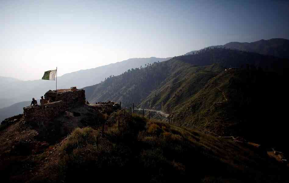 The Pakistani flag waves on the Afghan border at the Ghakhi Pass in Afghanistan's eastern Kunar province. The volatile border, marked by a coil of razor wire, has been a source of constant friction as insurgents pass through the mountainous region.