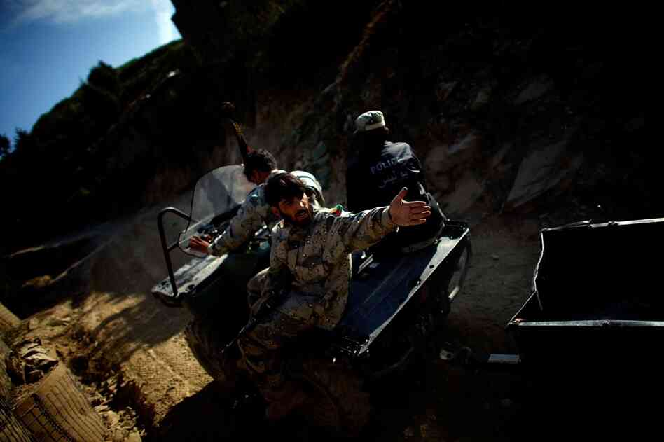 Afghan National Border Police move supplies along a makeshift road near the Ghakhi Pass. They were flown to the border area to secure the abandoned posts after the U.S. helicopter was attacked. The abandoned sites are troubling for soldiers in Alpha Company. Many have spent summers fighting against Taliban in the valley to the west and, they say, relying on the "Other Government Agency" to keep...