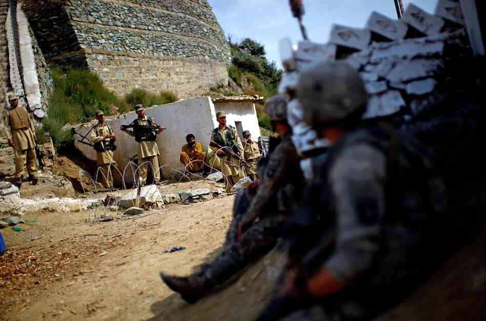 U.S. soldiers look over at members of Pakistan's paramilitary force as they stand guard at the Ghakhi Pass border. The U.S. soldiers have no way of knowing who might be associated with the Taliban.