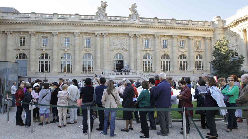 Visitors wait in line outside the Grand Palais museum in Paris.