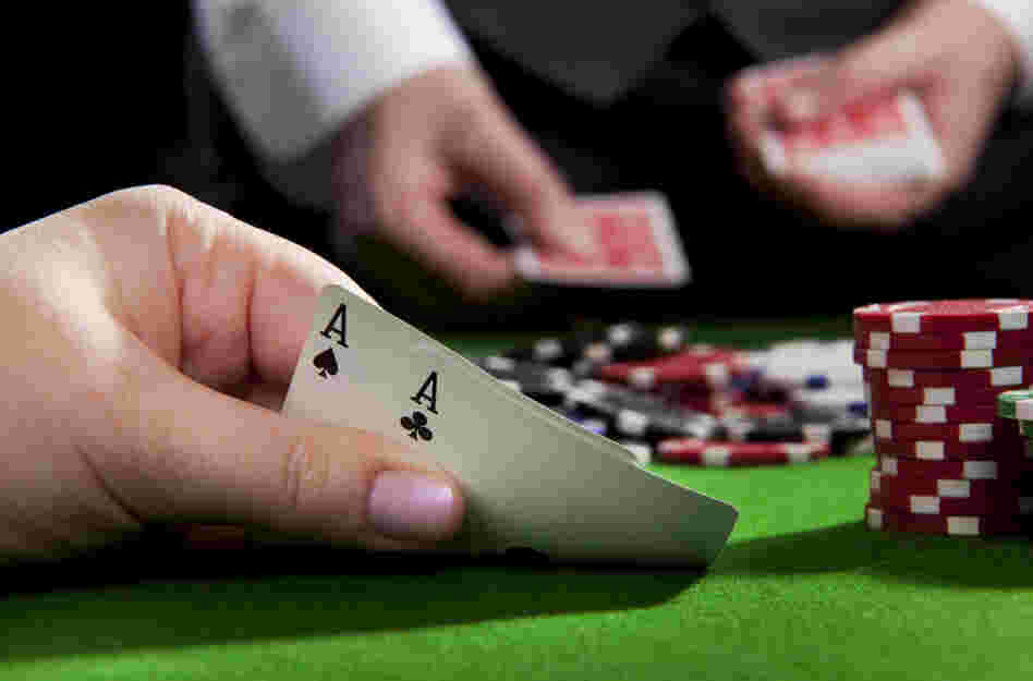 A woman holds a pair of aces at a poker table. A woman holds a pair of aces at a poker table.