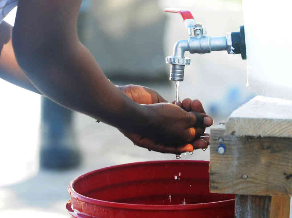 A healthcare worker washes her hands in A healthcare worker washes her hands in
