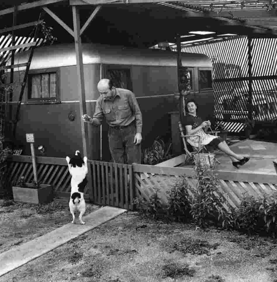 Residents of the Olympic Trailer Court in Santa Monica relax and play with their dog outside their trailer.