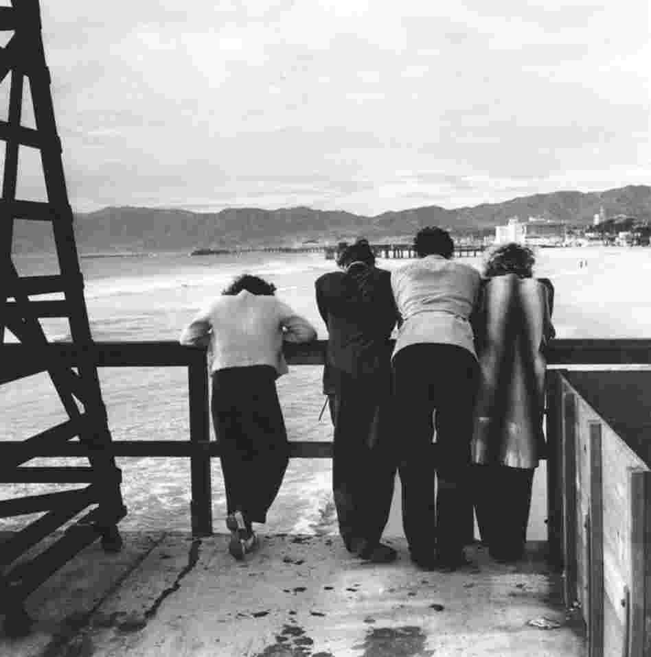 People stand on the Ocean Park Pier, looking north toward the Santa Monica Pier.