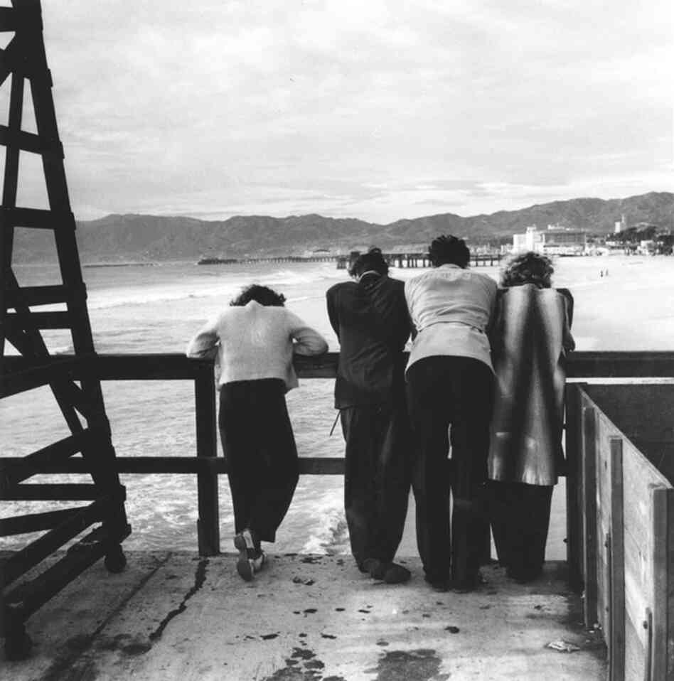 People stand on the Ocean Park Pier, looking north toward the Santa Monica Pier.