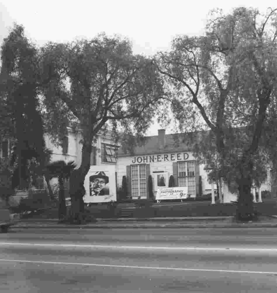 An exterior view of the photography studio owned by John E. Reed in Hollywood. On the lawn is a large photograph of entertainer Jimmy Durante.