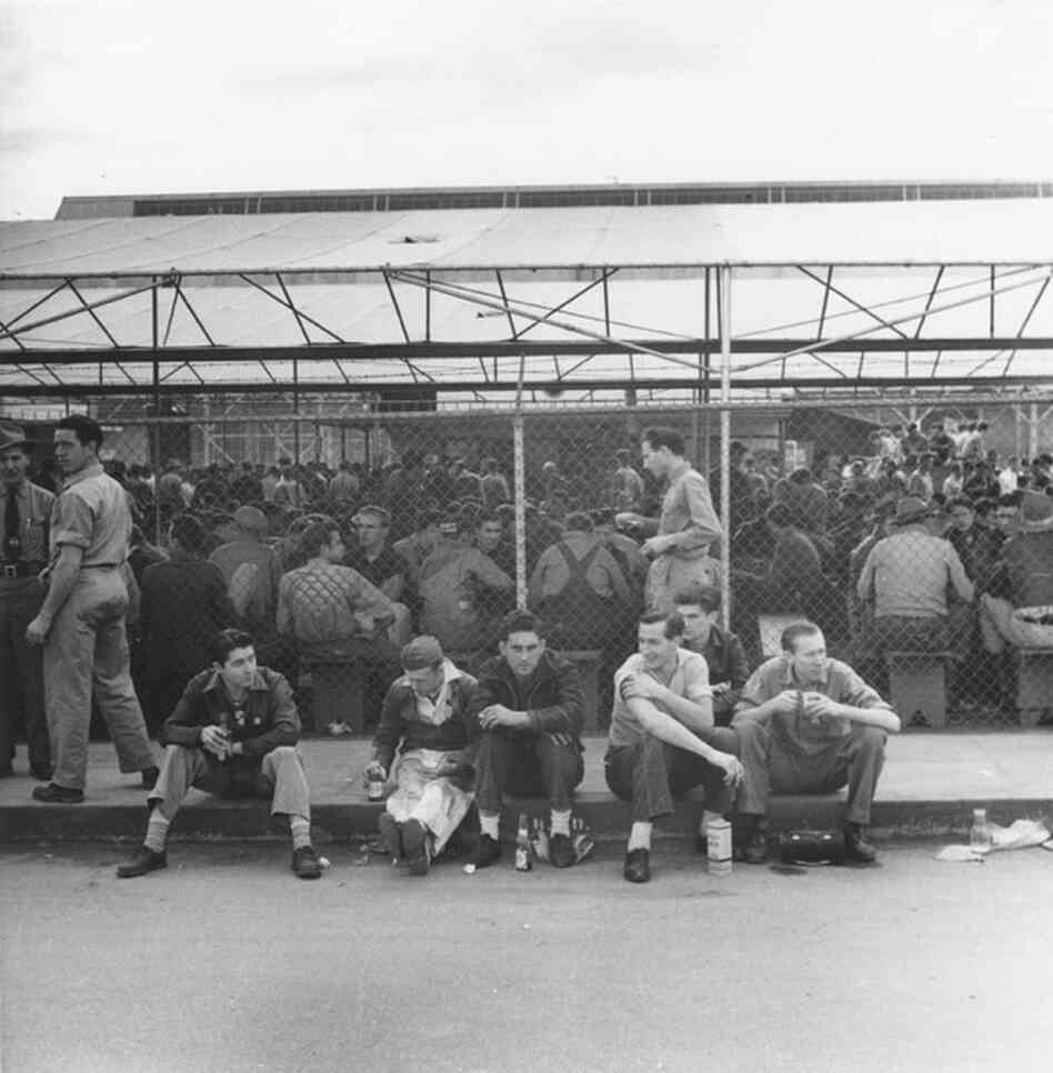 Hundreds of Burbank Lockheed Aircraft employees take a lunch break around a covered eating area.
