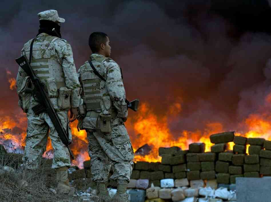 Two soldiers watch 134 tons of marijuana burning