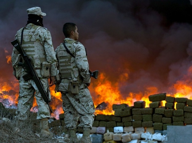 Two soldiers watch 134 tons of marijuana burning