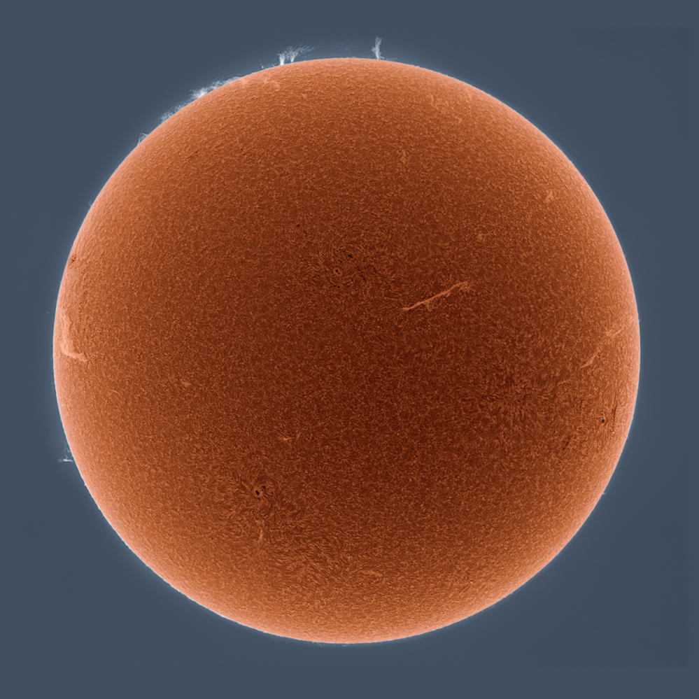 A portrait of the sun rendered in the hydrogen alpha spectrum.