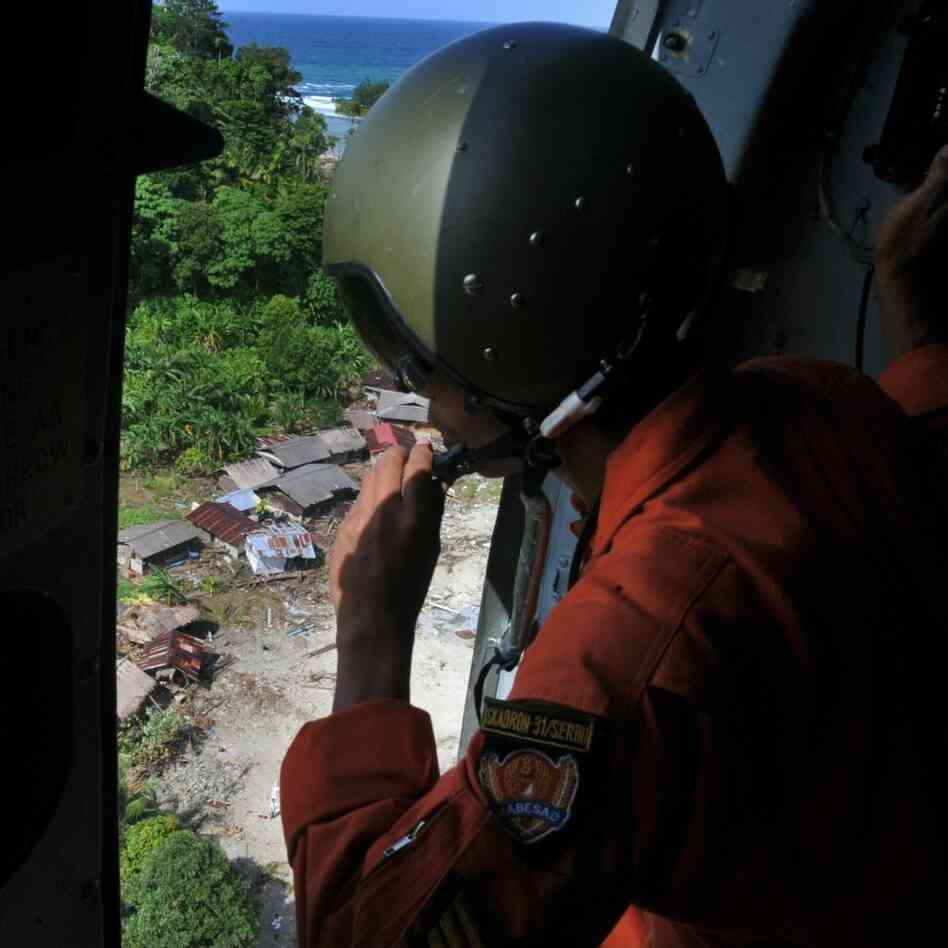 Sergeant Nandang observes a landing zone to drop relief aid in Metawai islands. Sergeant Nandang observes a landing zone to drop relief aid in Metawai islands.