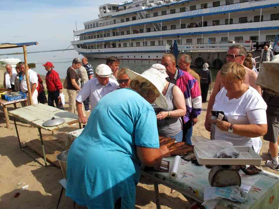 At one of the many port stops, travelers can purchase a variety of goods, like smoked fish, from locals.