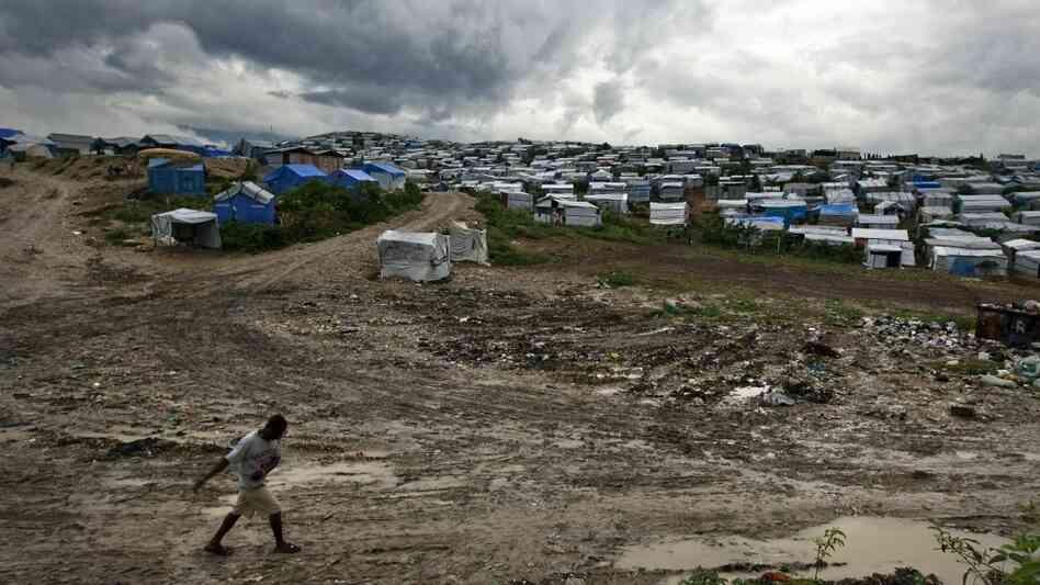 A man walks past a refugee camp A man walks past a refugee camp