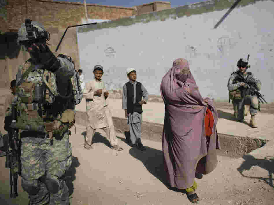 An Afghan woman walks among U.S. soldiers in Kandahar City. An Afghan woman walks among U.S. soldiers in Kandahar City.